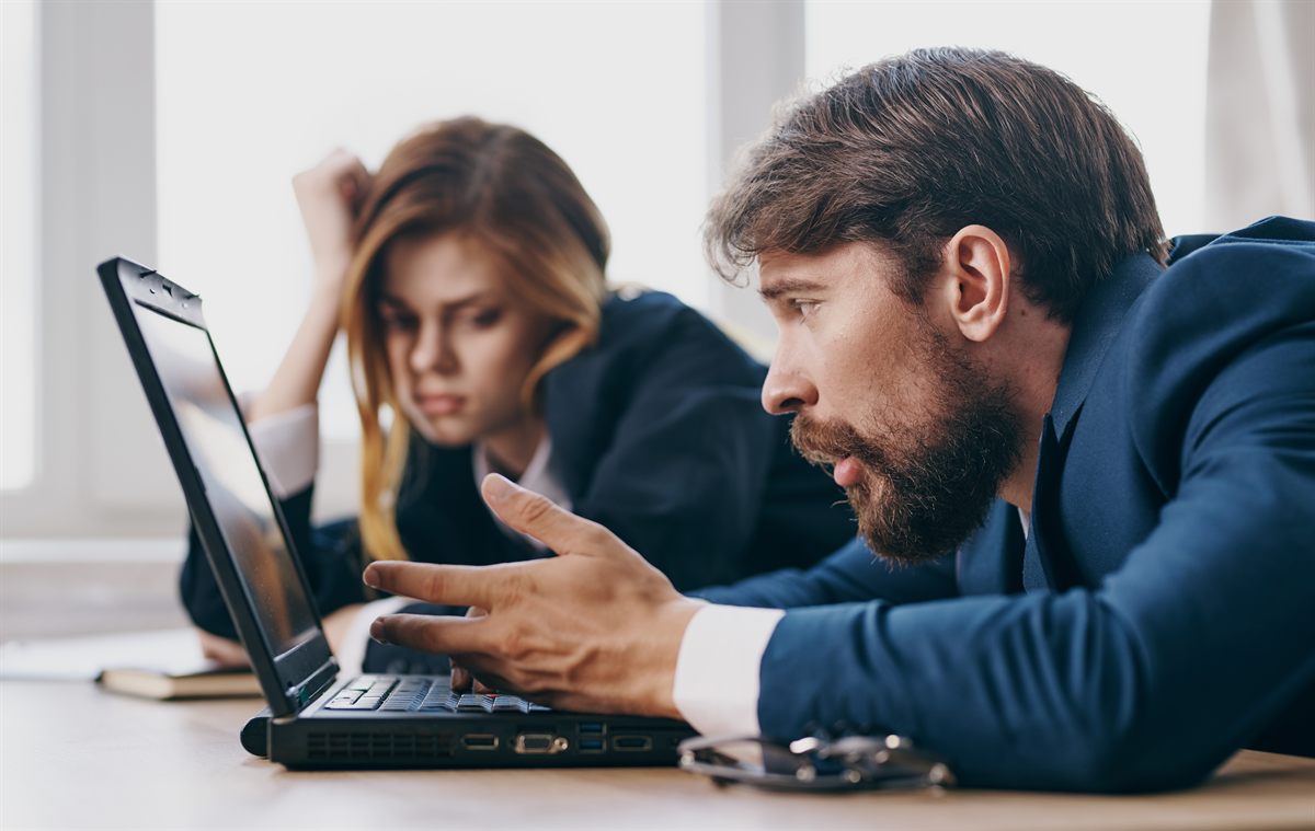 Dos profesionales resolviendo una incidencia técnica frente a un portátil